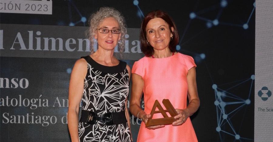 Marta López Alonso amosa o premio recibido de mans da directora da Axencia Española de Seguridade Alimentaria e Nutrición. Foto de 'Animal's Health'