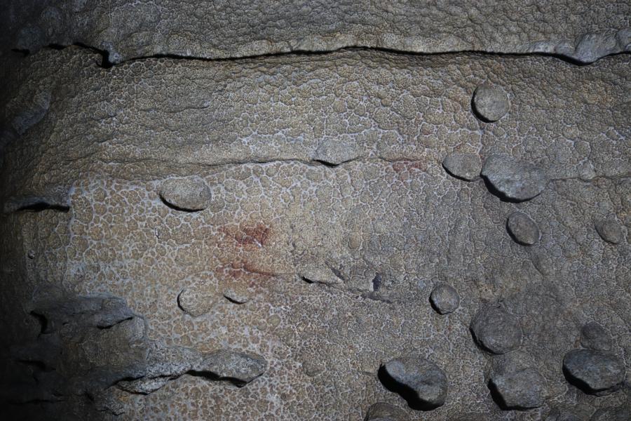 Puntos pintados en vermello no fondo da galería interior de Cova Eirós.