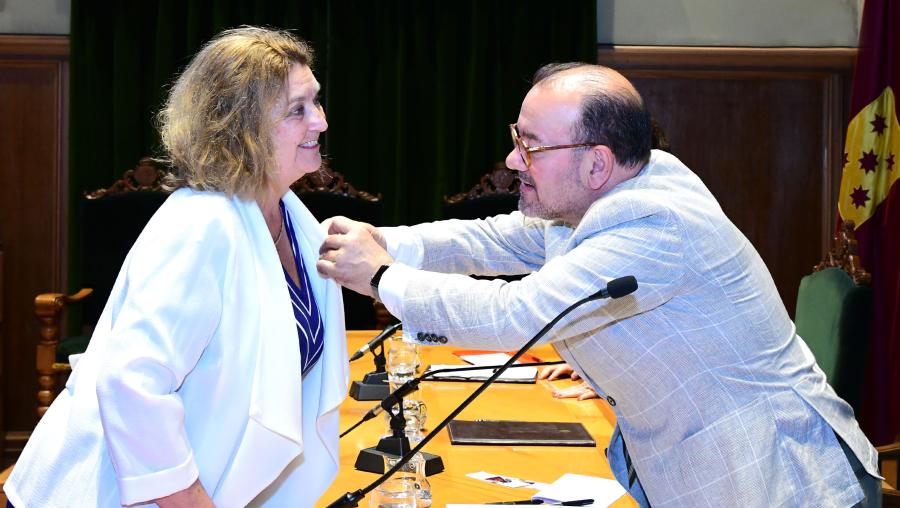 O reitor Antonio López colocándolle a Insignia de Ouro da USC a Catherine Davies. FOTO: Santi Alvite