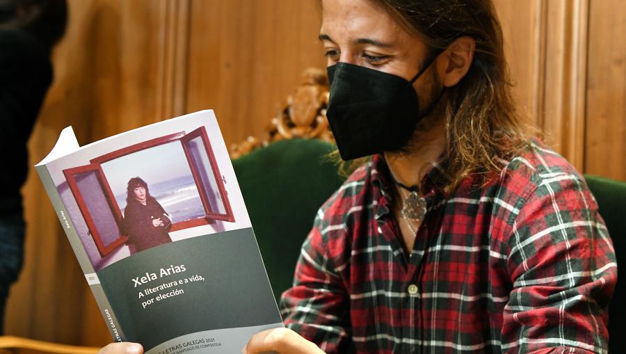 Darío, o fillo de Xela Arias, lendo o volume editado pola USC. FOTO: Santi Alvite