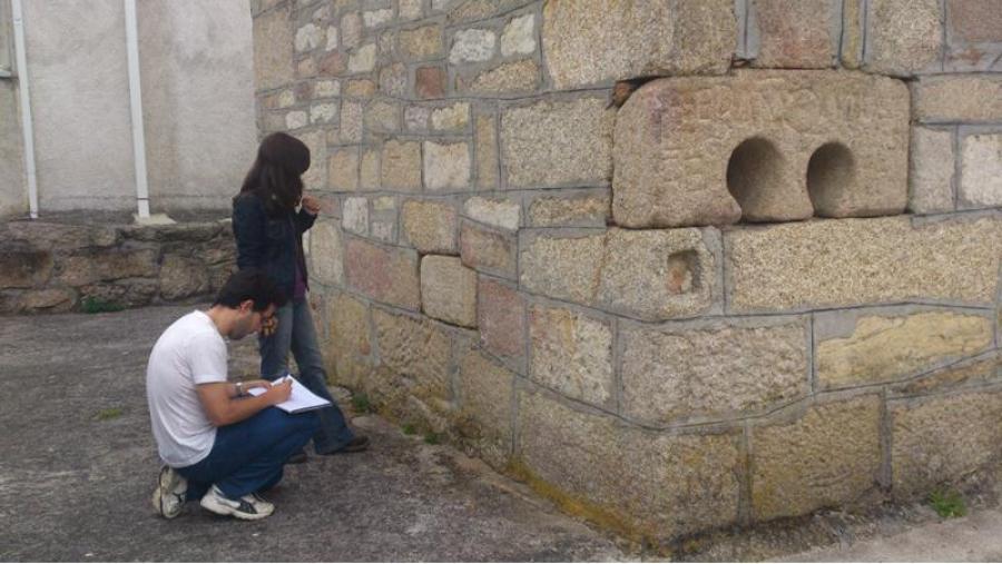 José Carlos Sánchez-Pardo e Leticia López documentando pezas altomedievais e romanas reempregadas nos muros exteriores da Capela de San Antón da Siota (Xunqueira de Ambía)