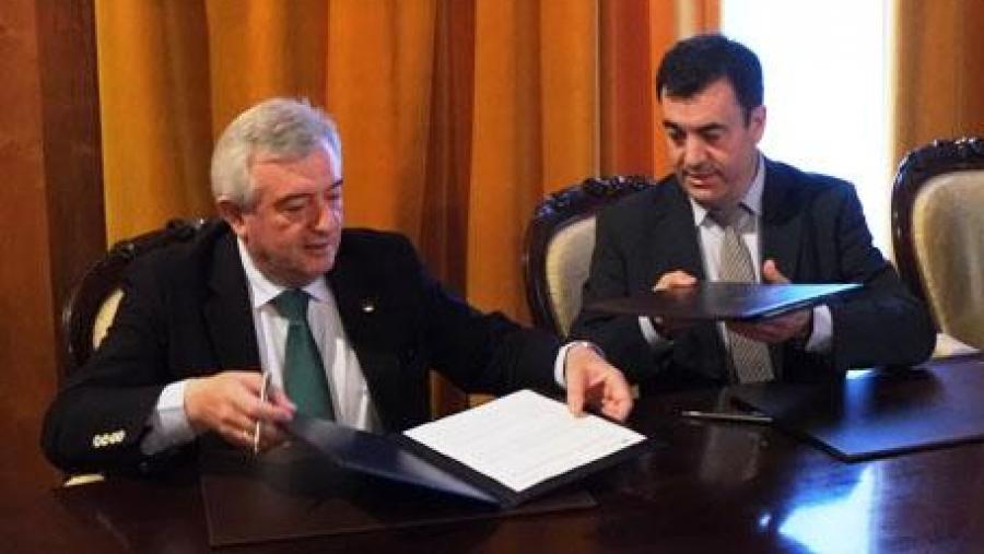 Juan Viaño e Román Rodríguez intercambian os convenios no momento da súa sinatura. Foto: Servimav-USC